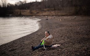 Colleen Sievert of Silver Bay sat on the shore of Lake Superior near the Split Rock River and looked for agates Sunday afternoon. Record-breaking warm