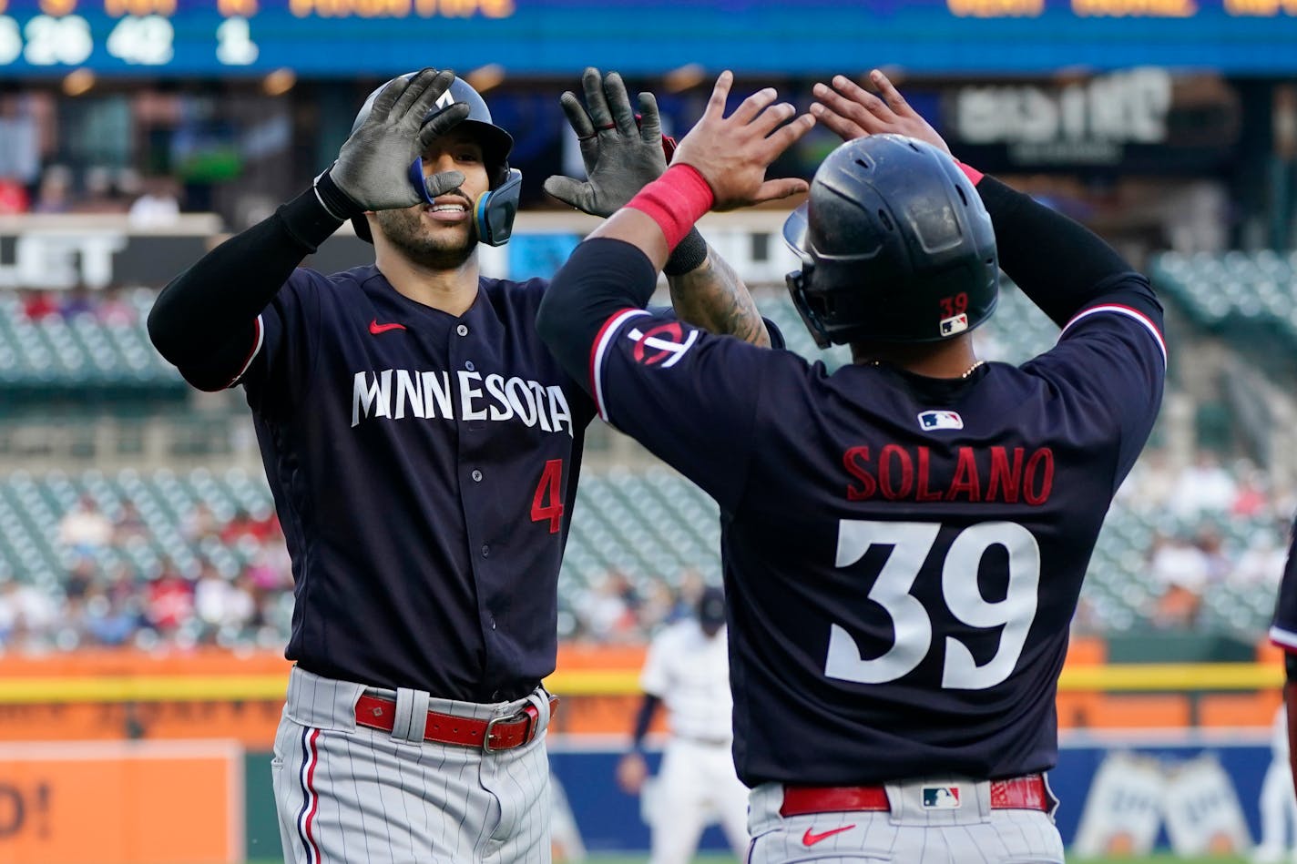 Minnesota Twins' Carlos Correa is greeted by Donovan Solano after hitting a three-run home run during the second inning of a baseball game against the Detroit Tigers, Monday, Aug. 7, 2023, in Detroit. (AP Photo/Carlos Osorio)