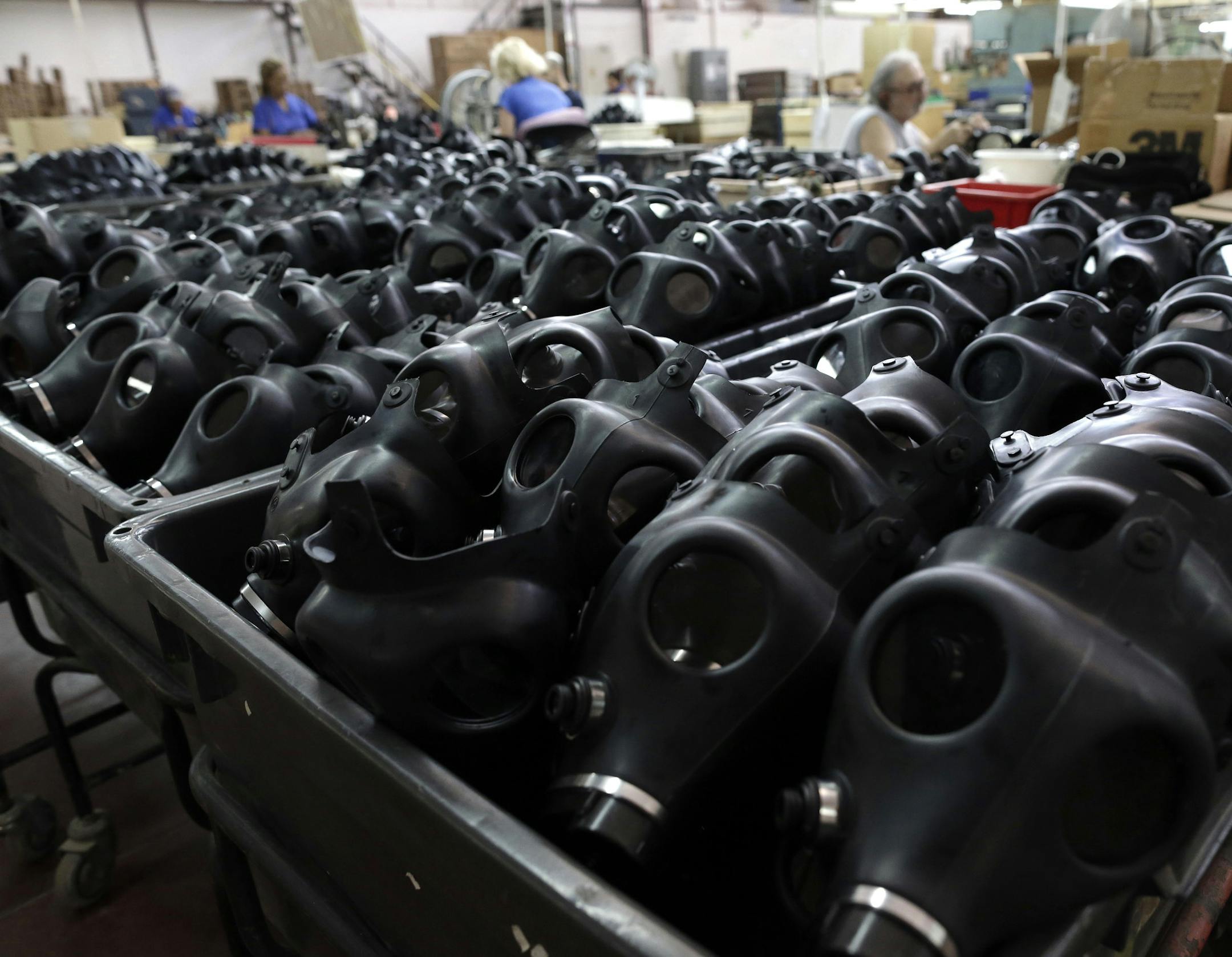 Israeli workers are seen at the Shalon gas mask factory in Kiryat Gat, Israel, Thursday, Aug. 29, 2013. Israeli police say thousands of Israelis are crowding gas-mask distribution facilities, readying for a potential conflict in Syria. (AP Photo/Tsafrir Abayov)
