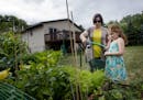 Ali Cuellar, 6, watched her mother Rebecca water their garden from a rain barrel setup on the deck of their Cottage Grove home. ] CARLOS GONZALEZ &#xe