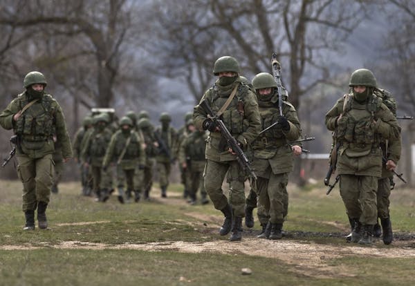 Pro-Russian soldiers march near a Ukrainian army base in Perevalne, Crimea, Wednesday, March 19, 2014.