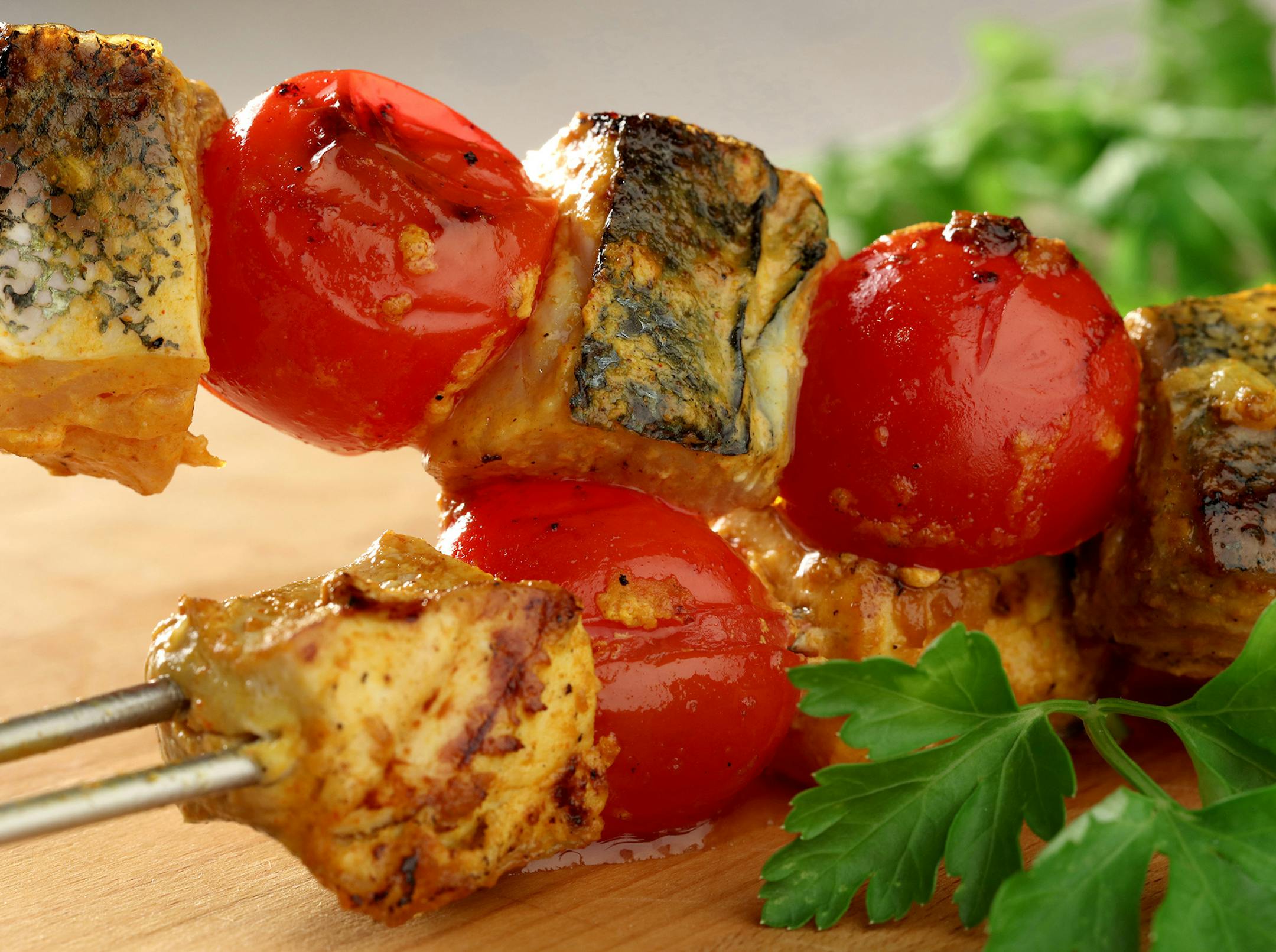 Mahi mahi kebabs are marinated in a spicy mixture, made with yogurt, onion, garlic, paprika and other spices, before being grilled along with fresh tomatoes. (Michael Tercha/Chicago Tribune/TNS) ORG XMIT: 1185286