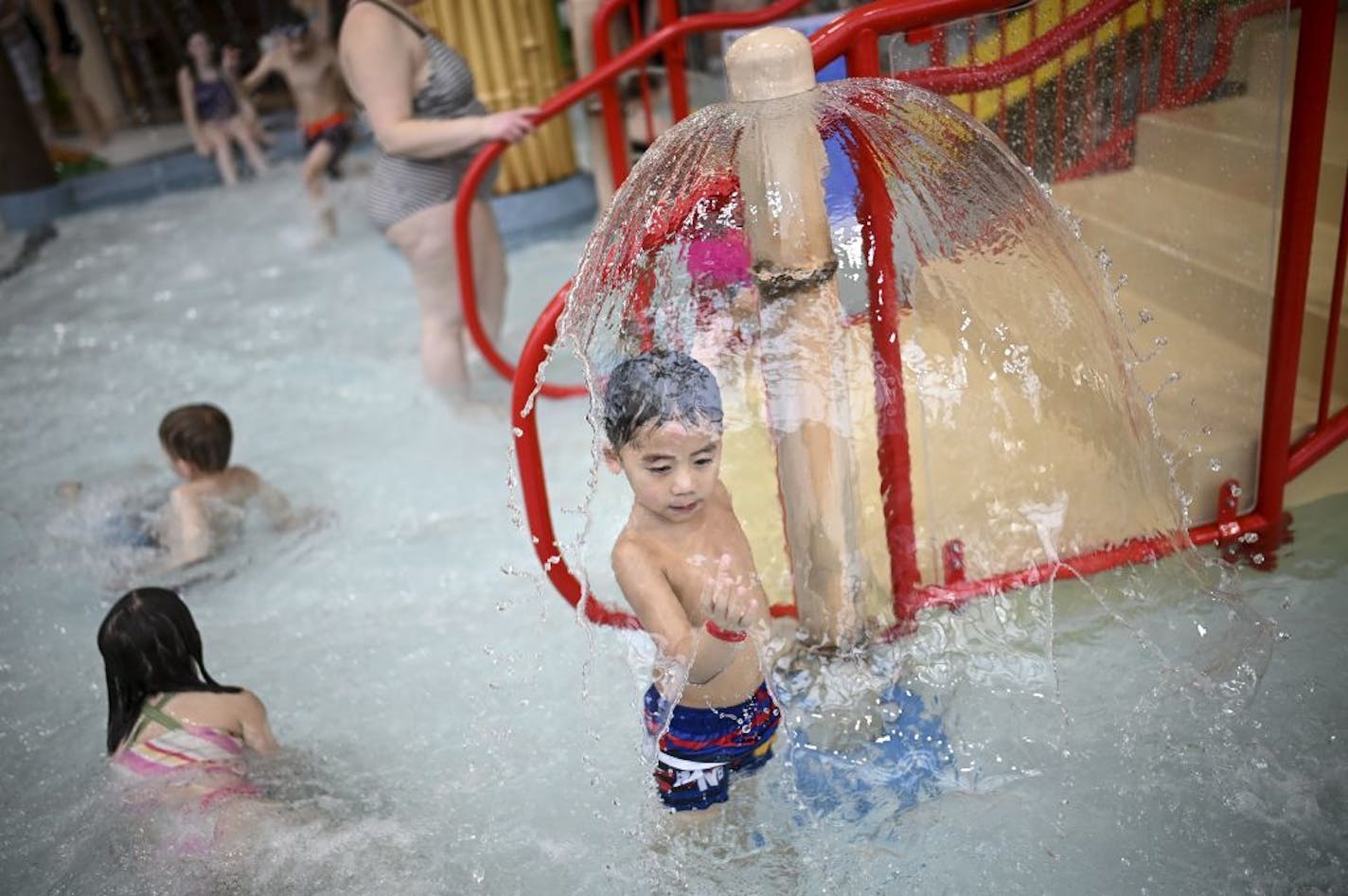 Zyran Vang, 4, of Brooklyn Park, played underneath a fountain in the expansion of the Shoreview Community Center's water park Friday afternoon.