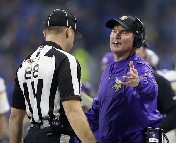 Minnesota Vikings head coach Mike Zimmer talks with field judge Brad Freeman during the second half of an NFL football game against the Detroit Lions,