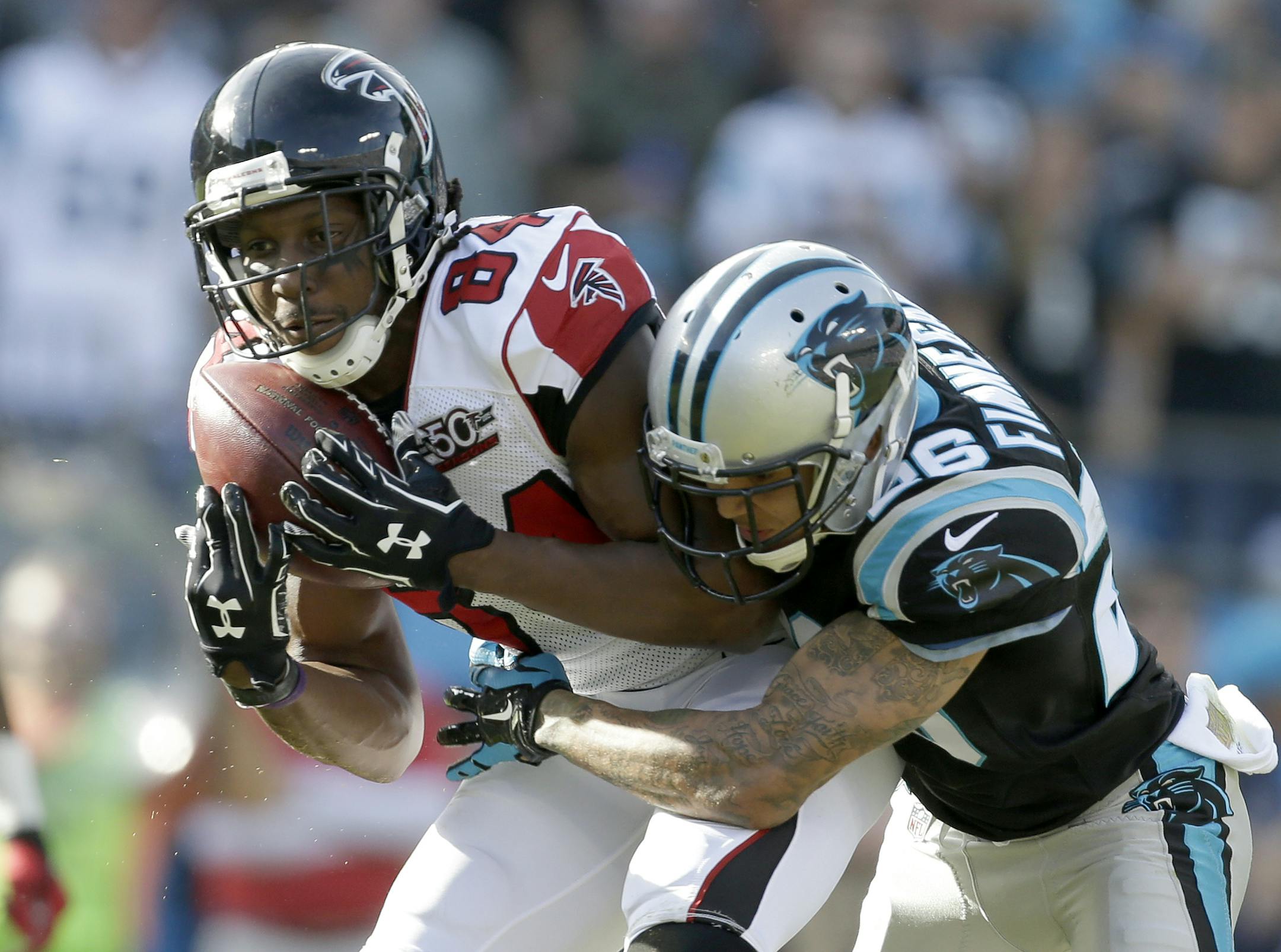 Atlanta Falcons' Roddy White (84) catches a pass as Carolina Panthers' Cortland Finnegan (26) defends in the first half of an NFL football game in Charlotte, N.C., Sunday, Dec. 13, 2015. (AP Photo/Bob Leverone) ORG XMIT: NCCB110