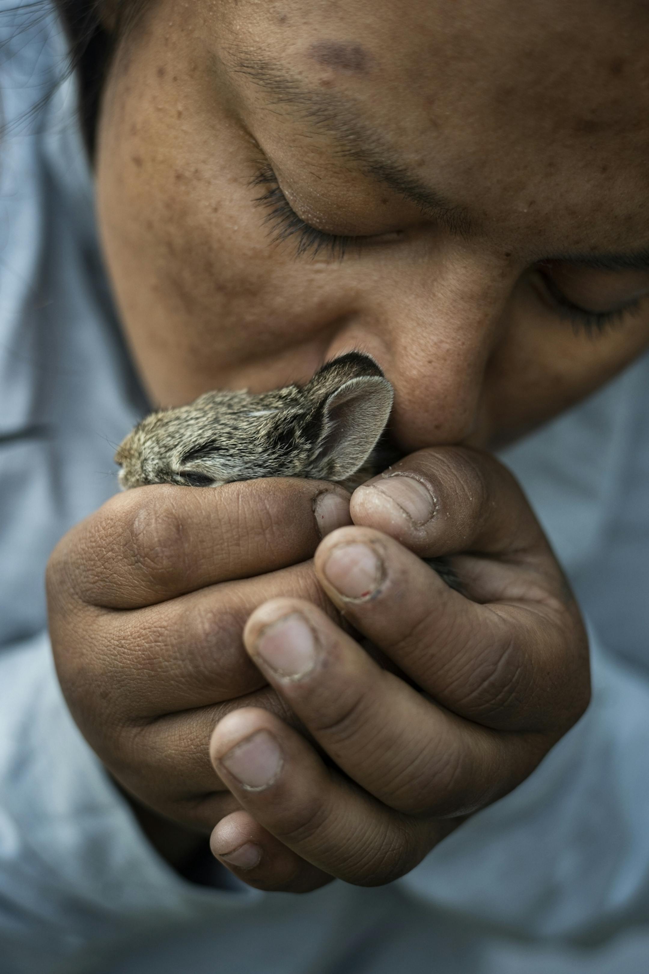 Amber Holmes plays with her pet rabbit which she found abandoned near the camp.