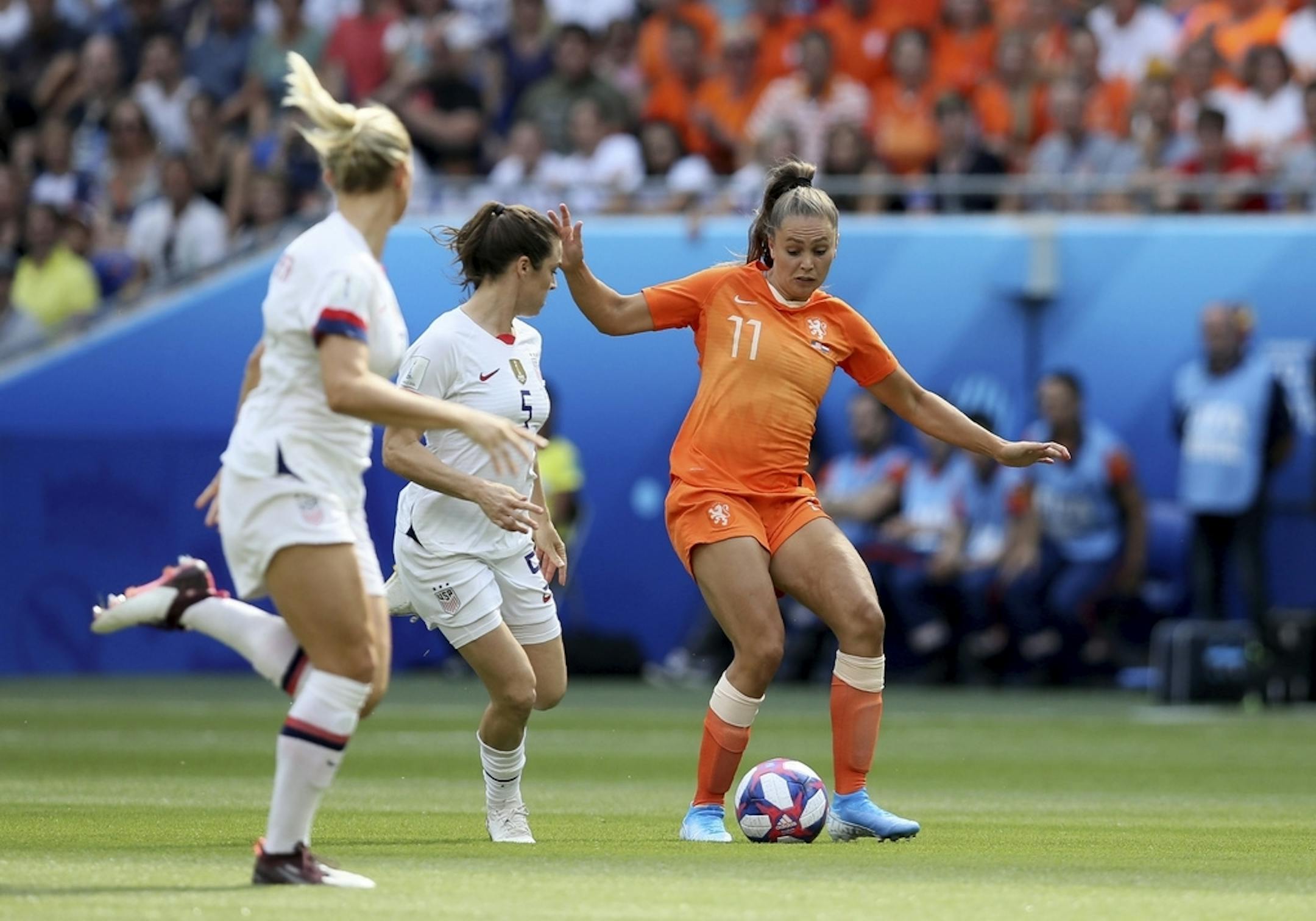 Netherlands' Lieke Martens, right, is challenged by United States' Kelley O Hara, center, during the Women's World Cup final soccer match between US and The Netherlands at the Stade de Lyon in Decines, outside Lyon, France, Sunday, July 7, 2019.