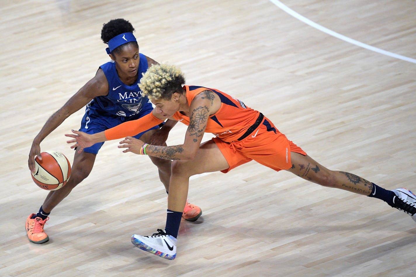 Connecticut Sun guard Natisha Hiedeman, right, attempts to steal a ball from Minnesota Lynx guard Crystal Dangerfield (2) during the first half of a WNBA basketball game, Sunday, July 26, 2020, in Bradenton, Fla. (AP Photo/Phelan M. Ebenhack)