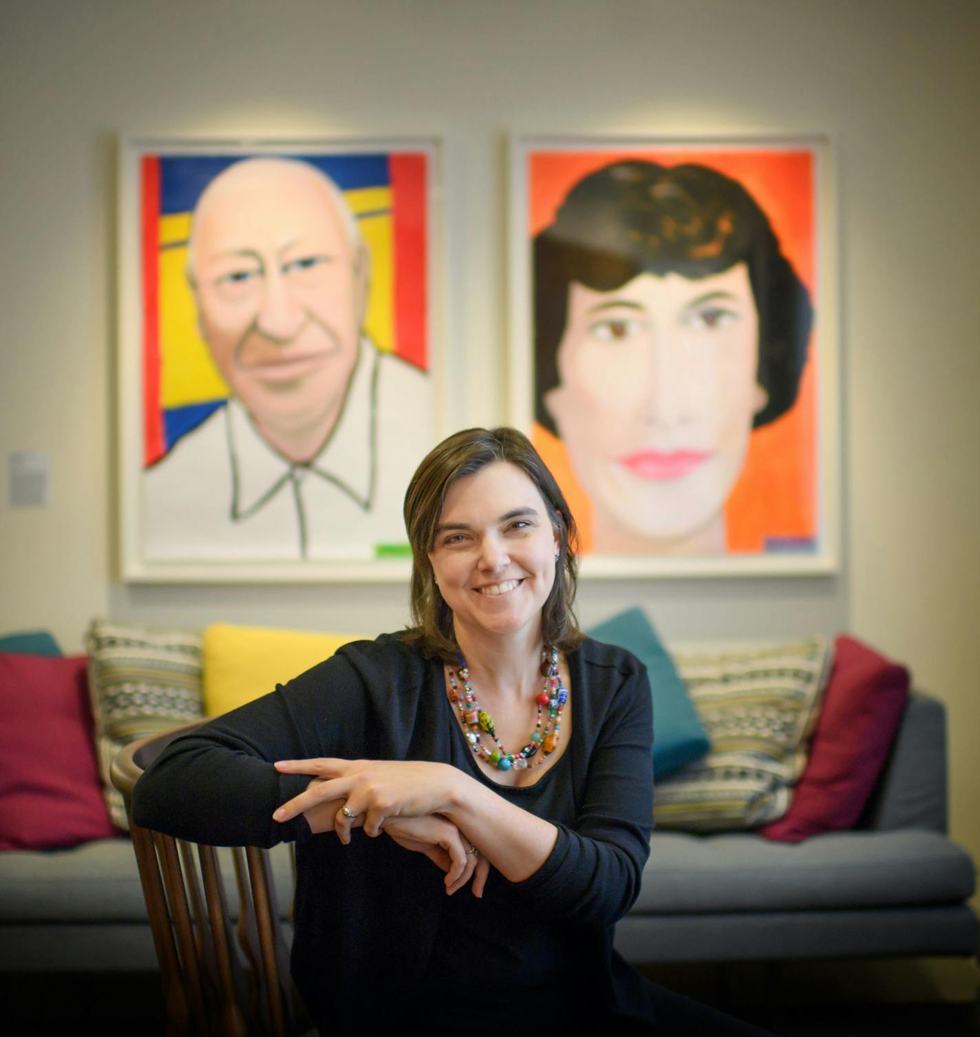 Jennifer Ford Reedy, Bush Foundation president, in front of portraits of Archibald and Edyth Bassler Bush done by Bush Fellow Frank Gaard.