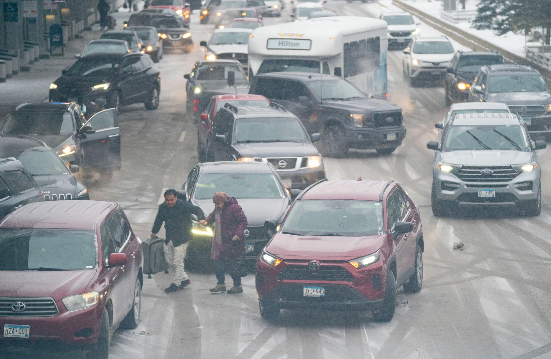 Travelers unload from cars at Terminal 1 of Minneapolis-Saint Paul International Airport.