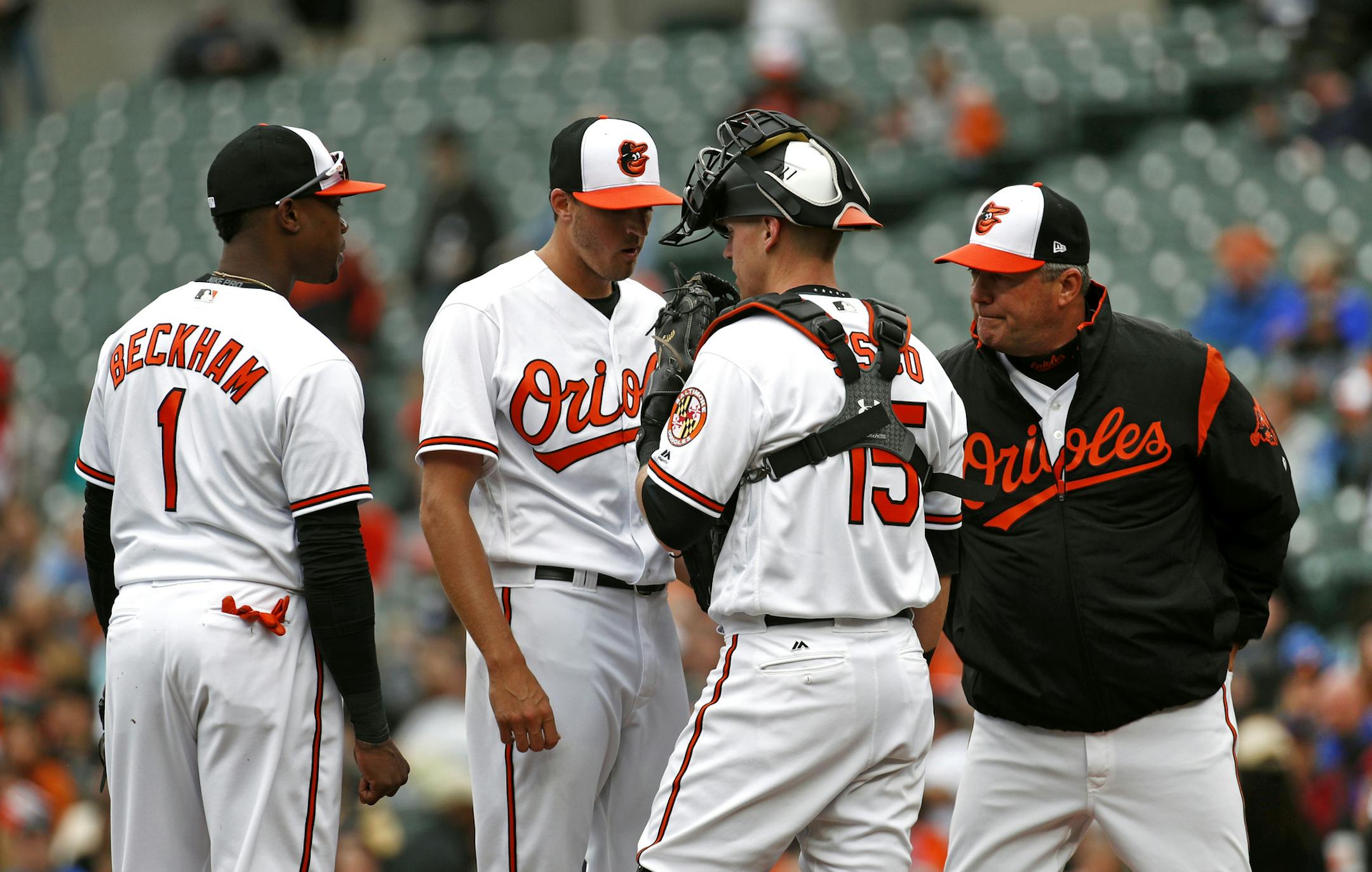 Baltimore Orioles starting pitcher Kevin Gausman, second from left, speaks with third baseman Tim Beckham (1), catcher Chance Sisco and pitching coach Roger McDowell in the first inning of a baseball game against the Minnesota Twins, Sunday, April 1, 2018, in Baltimore. Minnesota scored four runs against Gausman in the first and won 7-0. (AP Photo/Patrick Semansky)