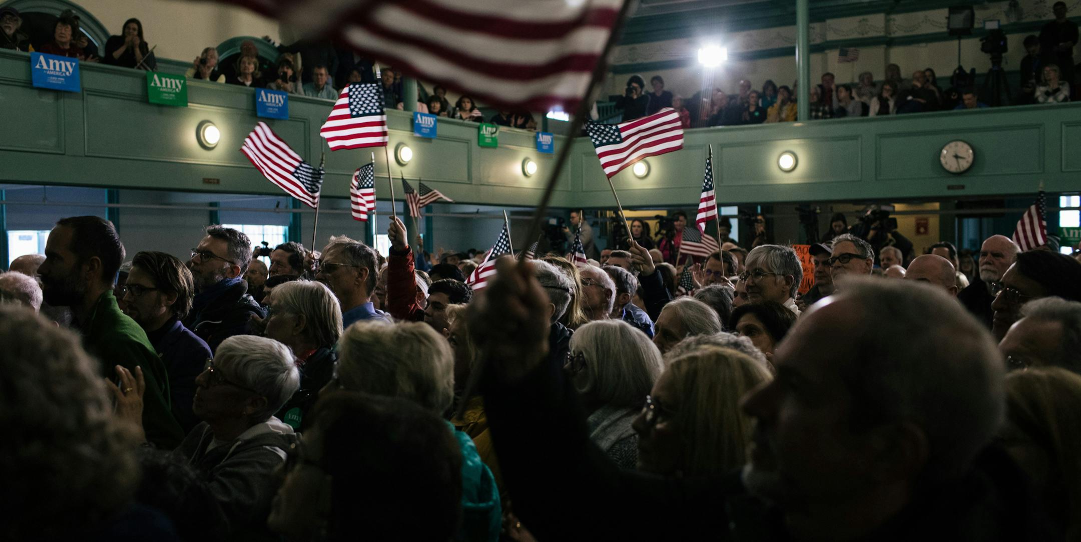 People wave flags during a campaign appearance by Sen. Amy Klobuchar (D-Minn.), a Democratic candidate for president, in Exeter, N.H. on Monday, Feb. 10, 2020. (Alyssa Schukar/The New York Times)