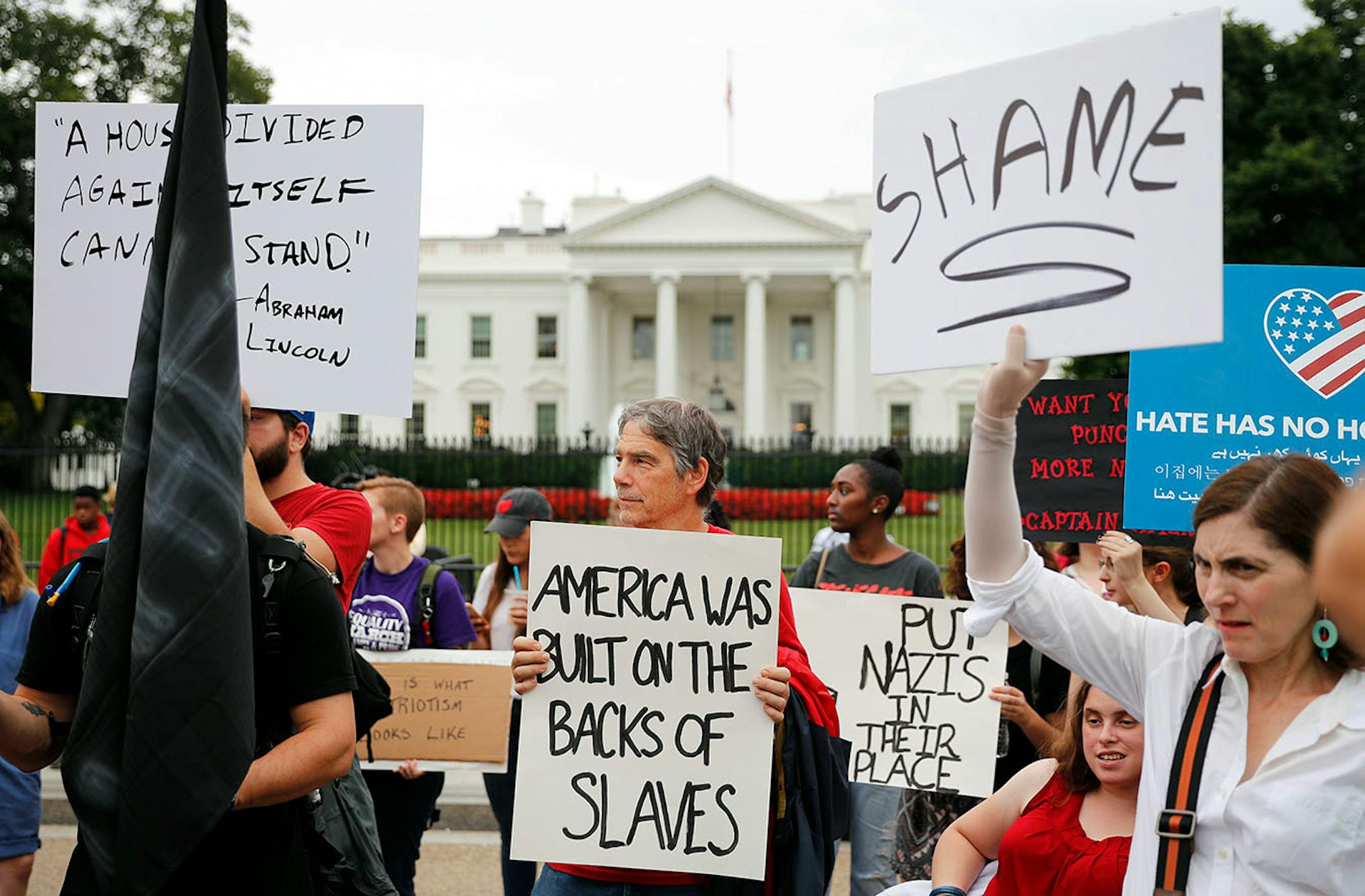 Demonstrators gather on Pennsylvania Avenue in front of the White House in Washington, Monday, Aug. 14, 2017. For the second night in a row, people gathered in front of the White House to protest the white nationalist rally in Charlottesville, Va.