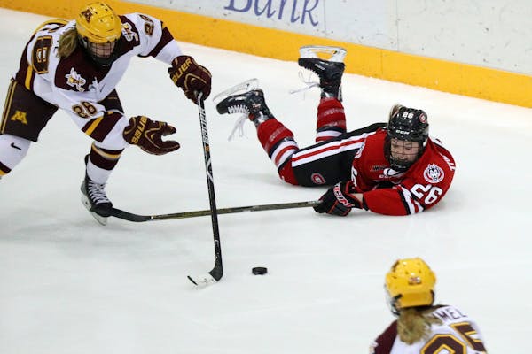 Minnesota Golden Gophers forward Taylor Wente (28) took the puck from St. Cloud State Huskies forward/defenseman Hallie Theodosopoulos (26) after she 