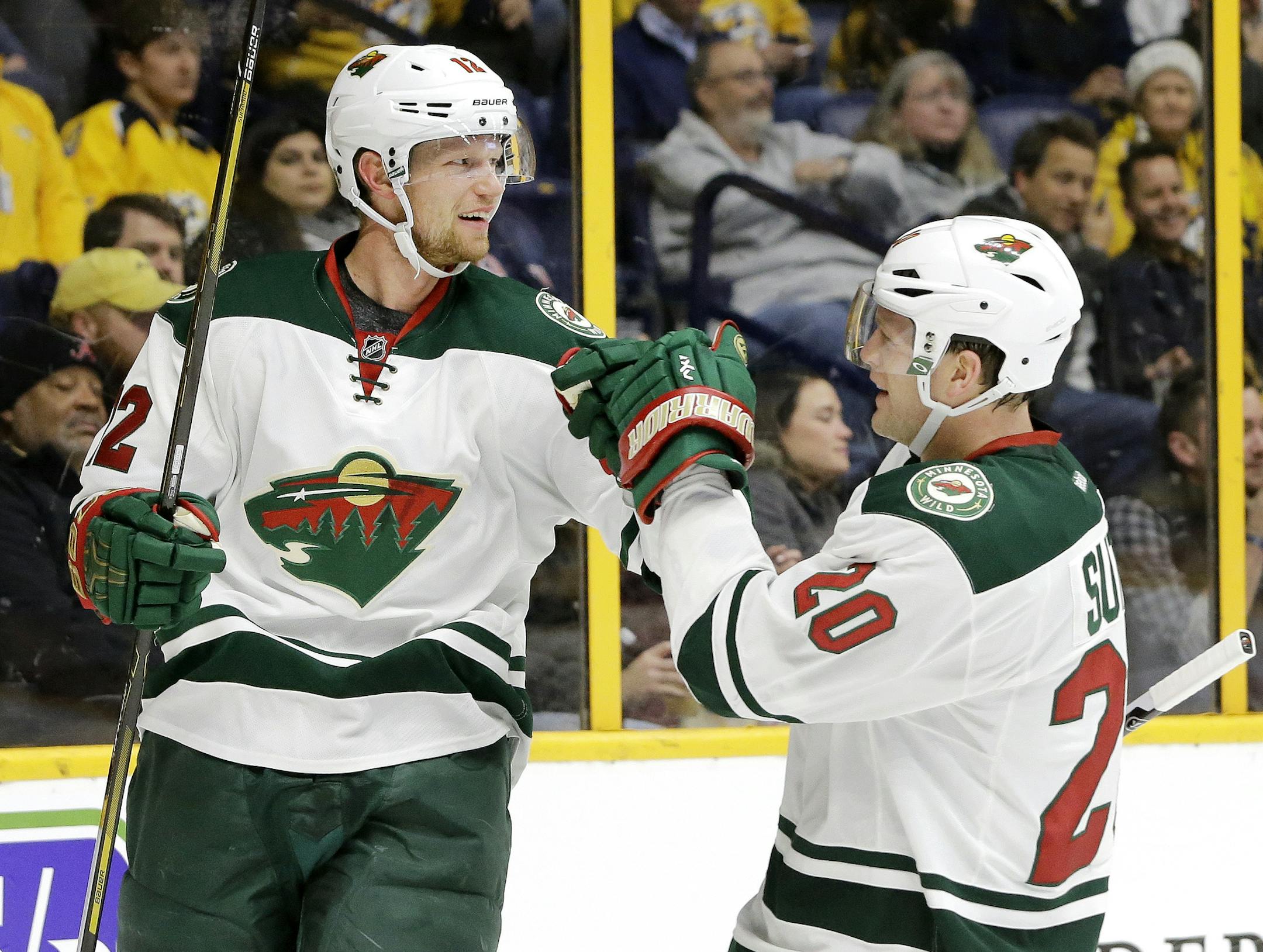 Minnesota Wild center Eric Staal (12) celebrates with Ryan Suter (20) after Staal scored a goal against the Nashville Predators during the first period of an NHL hockey game Thursday, Dec. 15, 2016, in Nashville, Tenn. (AP Photo/Mark Humphrey)