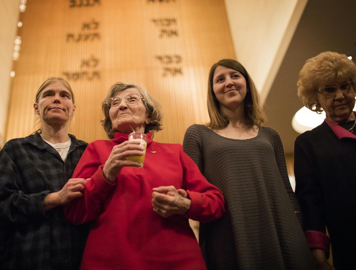 Holocaust survivor Renate Esquivel, center, is accompanied by her granddaughter Anna McCallum, to her left, and Holocaust survivor Reva Kibort, far right, is accompanied by her granddaughter Gracie Kibort, to her left, during the survivor candle lighting. ] LEILA NAVIDI &#xd4; leila.navidi@startribune.com BACKGROUND INFORMATION: The Twin Cities Annual Yom HaShoah Commemoration at Mount Zion Temple in St. Paul on Thursday, April 12, 2018. ORG XMIT: MIN1804122040140952