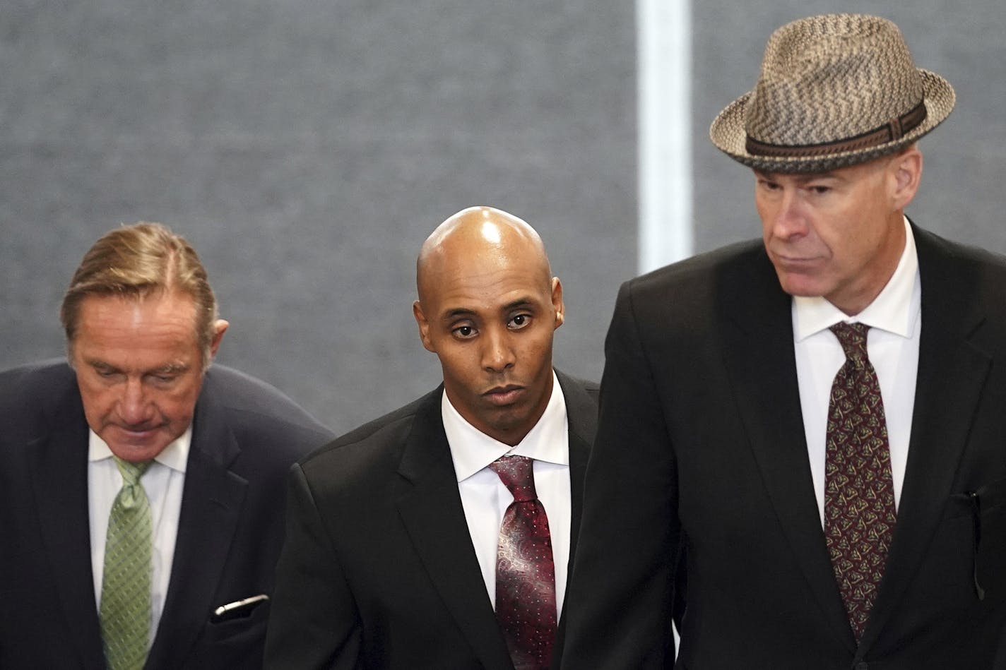 Mohamed Noor, center, accompanied by his legal team, Peter Wold, left, and Tom Plunkett, arrive to argue pretrial motions at a probable cause hearing for the ex-Minneapolis police officer Thursday, Sept. 27, 2018 at the Hennepin County Government Center in Minneapolis.