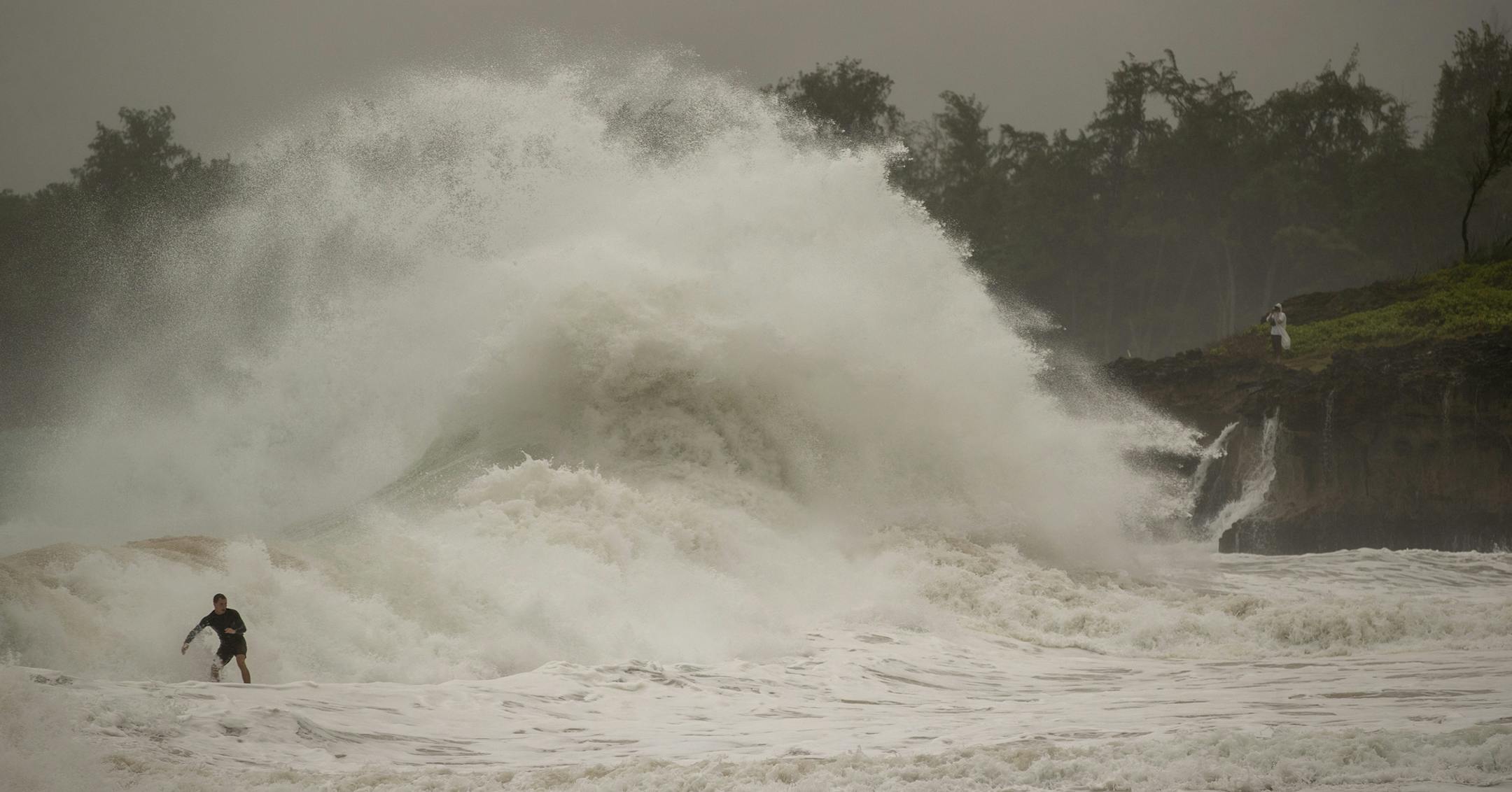A surfer takes on a wave generated by Hurricane Douglas at Laie Beach Park, Sunday, July 26, 2020, in Laie, Hawaii. (AP Photo/Eugene Tanner)