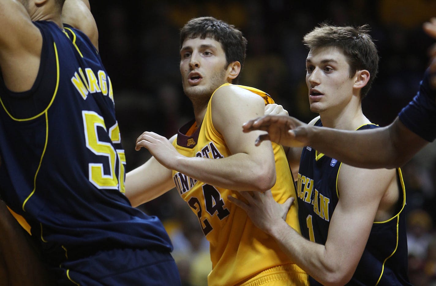 Minnesota's Blake Hoffarber was sandwiched beneath the basket under tight defense by Michigan's Stu Douglass (cq).