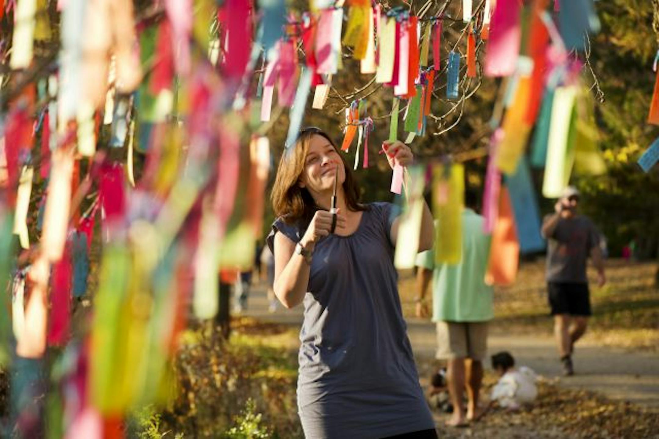 Hokey Pokey Project mastermind Deb Arora undressed the "wishing tree" near Lake Harriet by snipping off all the "wishes," which she saved.