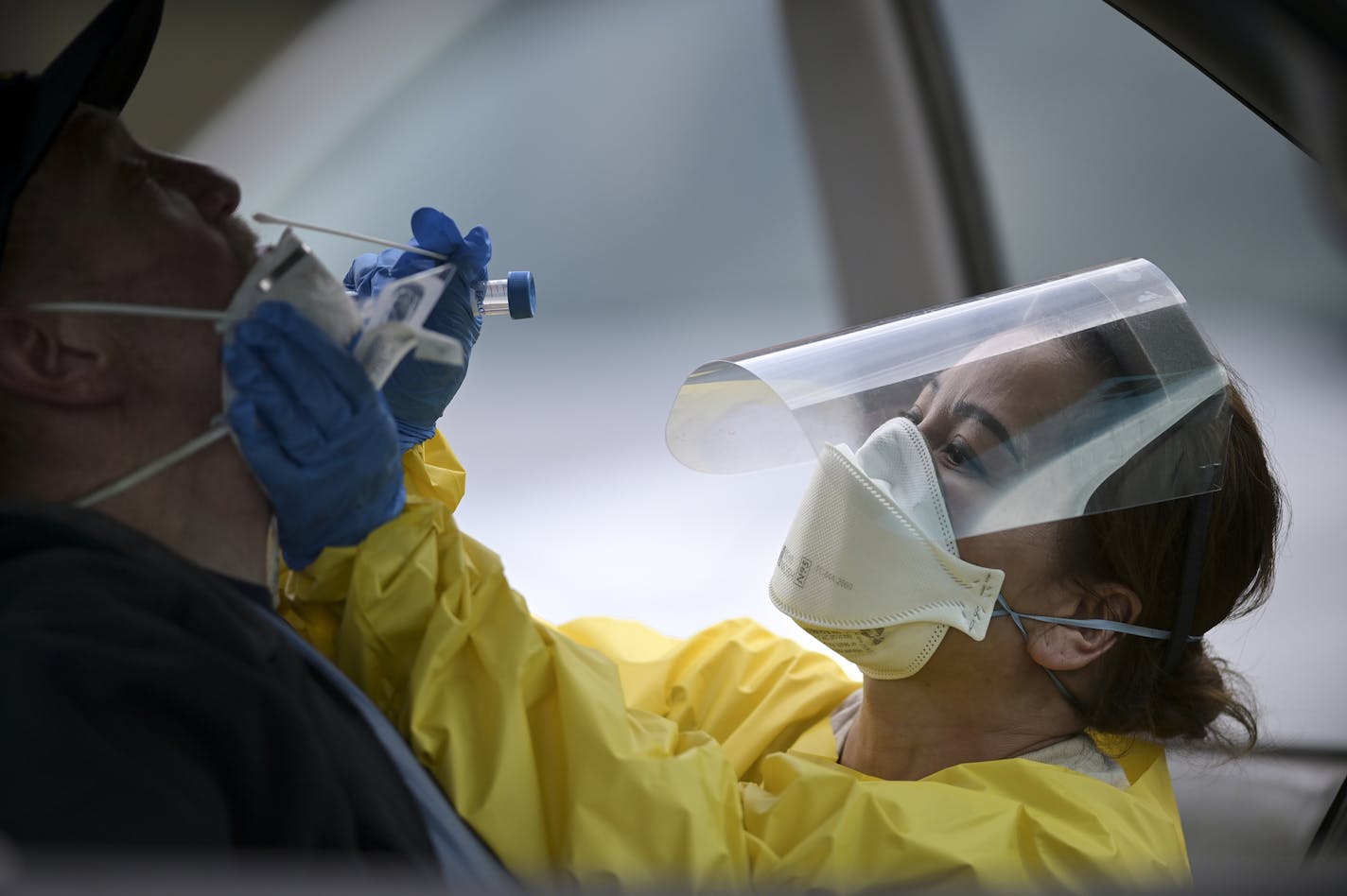 Elizabeth Santoro, a medic with the Minnesota Air National Guard 133rd Medical Group, administered a free COVID-19 test to Thomas Harmon, 61, of Robbinsdale, in May.