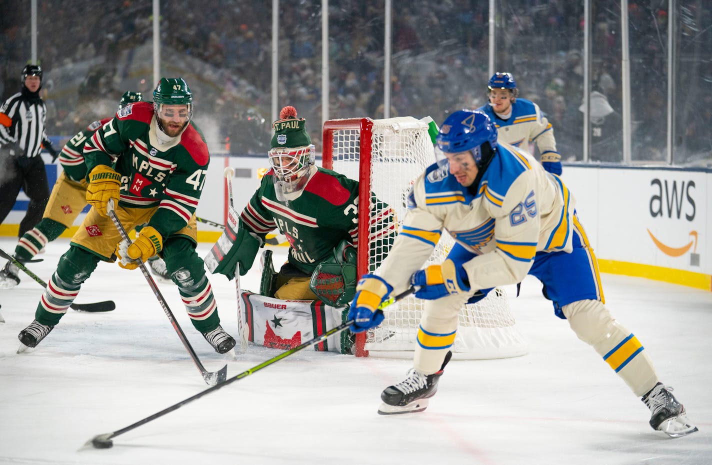 Minnesota Wild goaltender Cam Talbot (33) watches as St. Louis Blues center Jordan Kyrou (25) controls the puck in front of the net in the second period of the 2022 Winter Classic Saturday, Jan. 01, 2022 in Minneapolis, Minn. ]