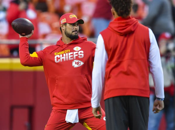 Kansas City Chiefs quarterback Matt Moore warms up, as an injured Patrick Mahomes, right, looks on, before a game against the Green Bay Packers on Sun