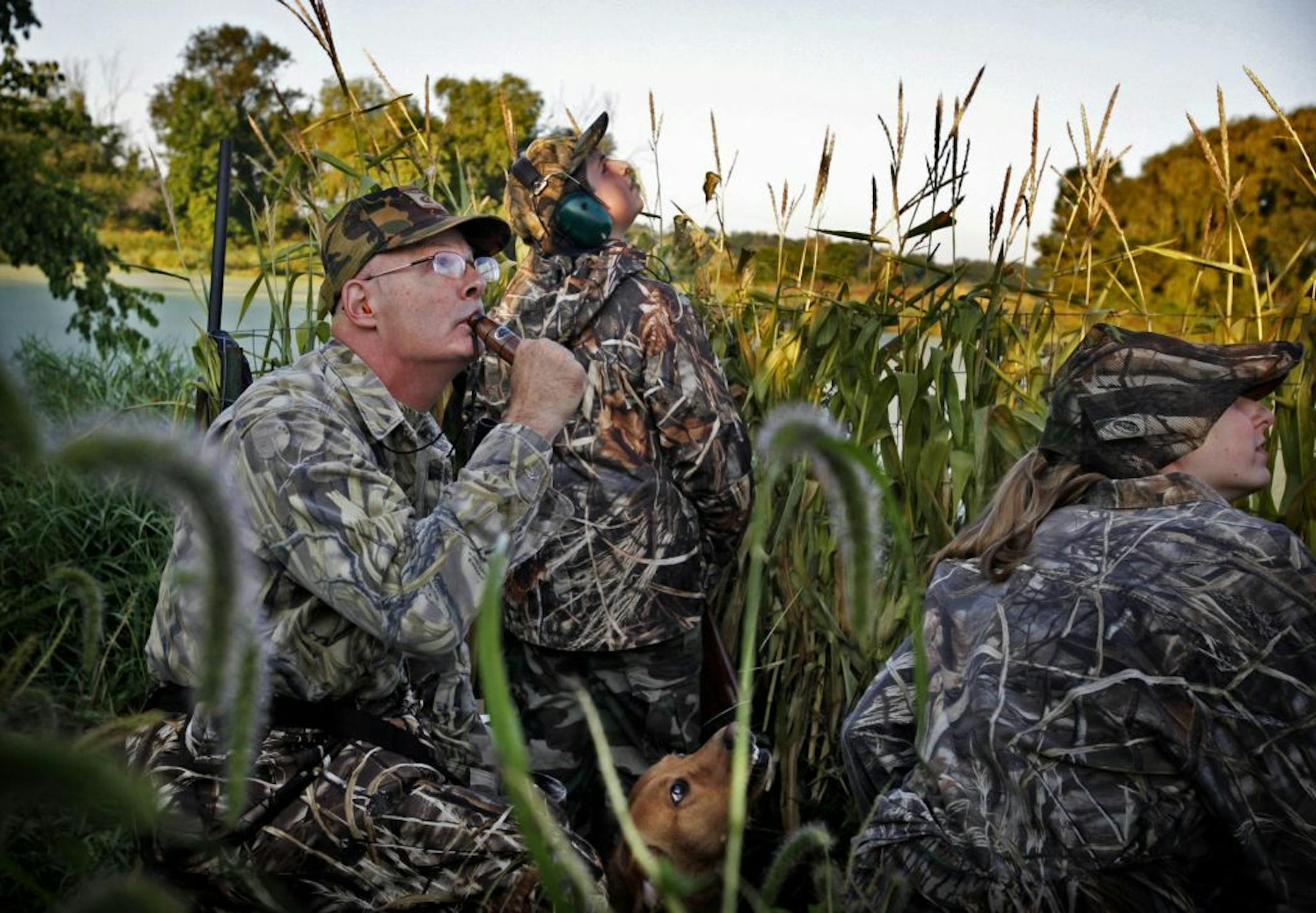 At Saturday's youth waterfowl hunt, DNR Commissioner Tom Landwehr, left, called to some ducks while his son Hunter, 13, their dog, Winni, and hunting mentor Alex Larson, 20, of Mounds View looked on.