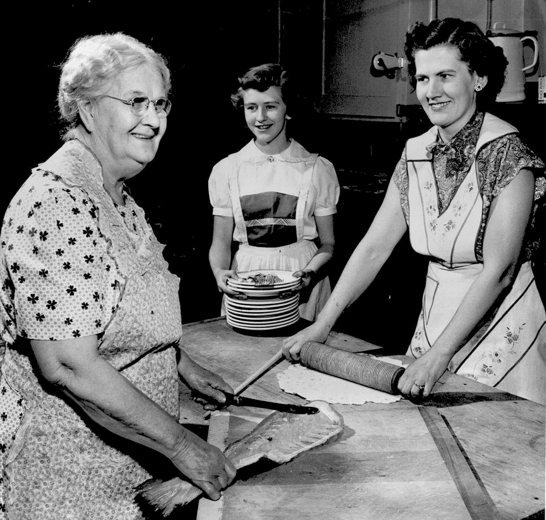 December 2, 1952 Lutefisk for Three Generations: Grandmother, mother and daughter all work together to prepare lutefisk for Zion Lutheran church's annual supper Wednesday and Thursday. Mrs. Peter Balstad, left, 3343 N. Fourth street, cuts the lutefisk, while her daughter, Mrs. Arnold Westby, 3612 Zenith avenue N., and granddaughter, Judith Westby, 12, share in preparation for the church affair. Minneapolis Star Tribune