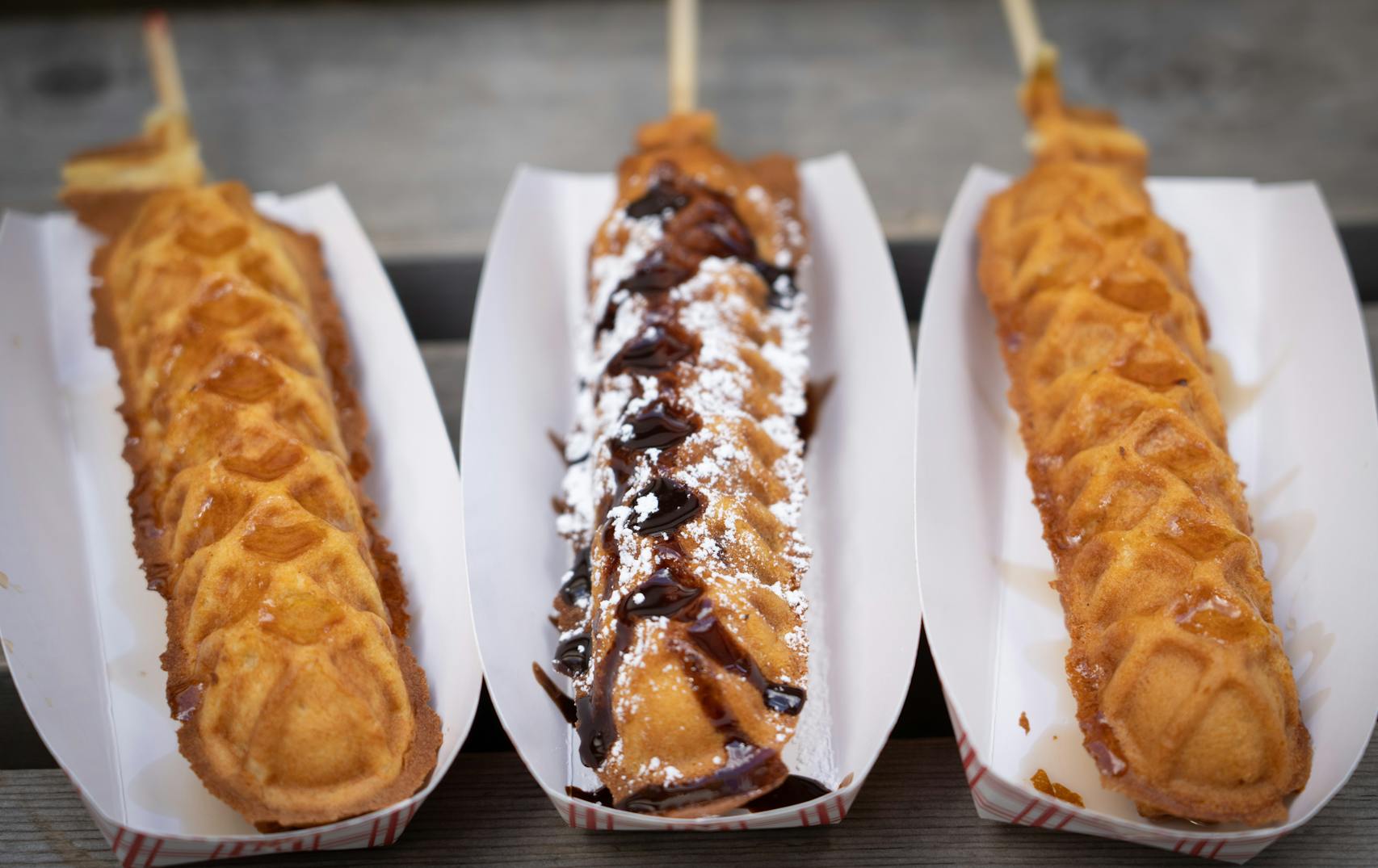 Breakfast Sausage in a Waffle On-A-Stick, Brownie Waffle Stick and Chicken in a Waffle On-A-Stick from Waffle Chix. New foods at the Minnesota State Fair photographed on Thursday, Aug. 25, 2022 in Falcon Heights, Minn. ] RENEE JONES SCHNEIDER • renee.jones@startribune.com
