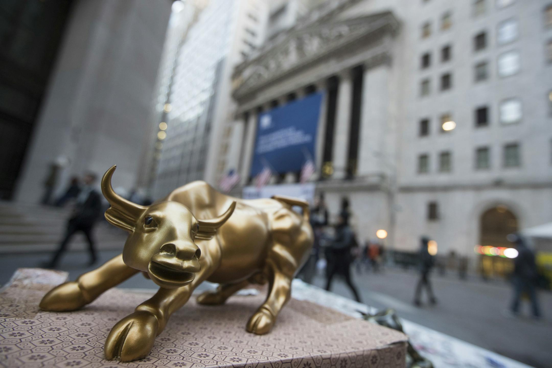 FILE - In this Tuesday, Oct. 25, 2016, file photo, a miniature reproduction of Arturo Di Modica's "Charging Bull" sculpture sits on display at a street vendor's table outside the New York Stock Exchange, in lower Manhattan. Materials companies led U.S. stock indexes slightly higher in early trading Tuesday, Jan. 24, 2017, as investors sized up the latest round of company earnings news. Energy stocks also rose as crude oil prices headed higher. Phone companies and health care stocks lagged the br