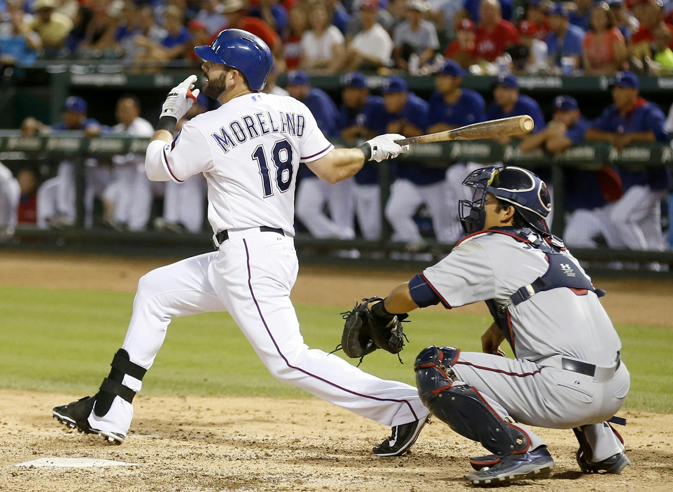 Texas Rangers' Mitch Moreland (18) hits a two-run double as Minnesota Twins catcher Kurt Suzuki looks on in the eighth inning of a baseball game Friday, June 12, 2015, in Arlington, Texas. The Rangers defeated the Twins 6-2. (AP Photo/Ron Jenkins)