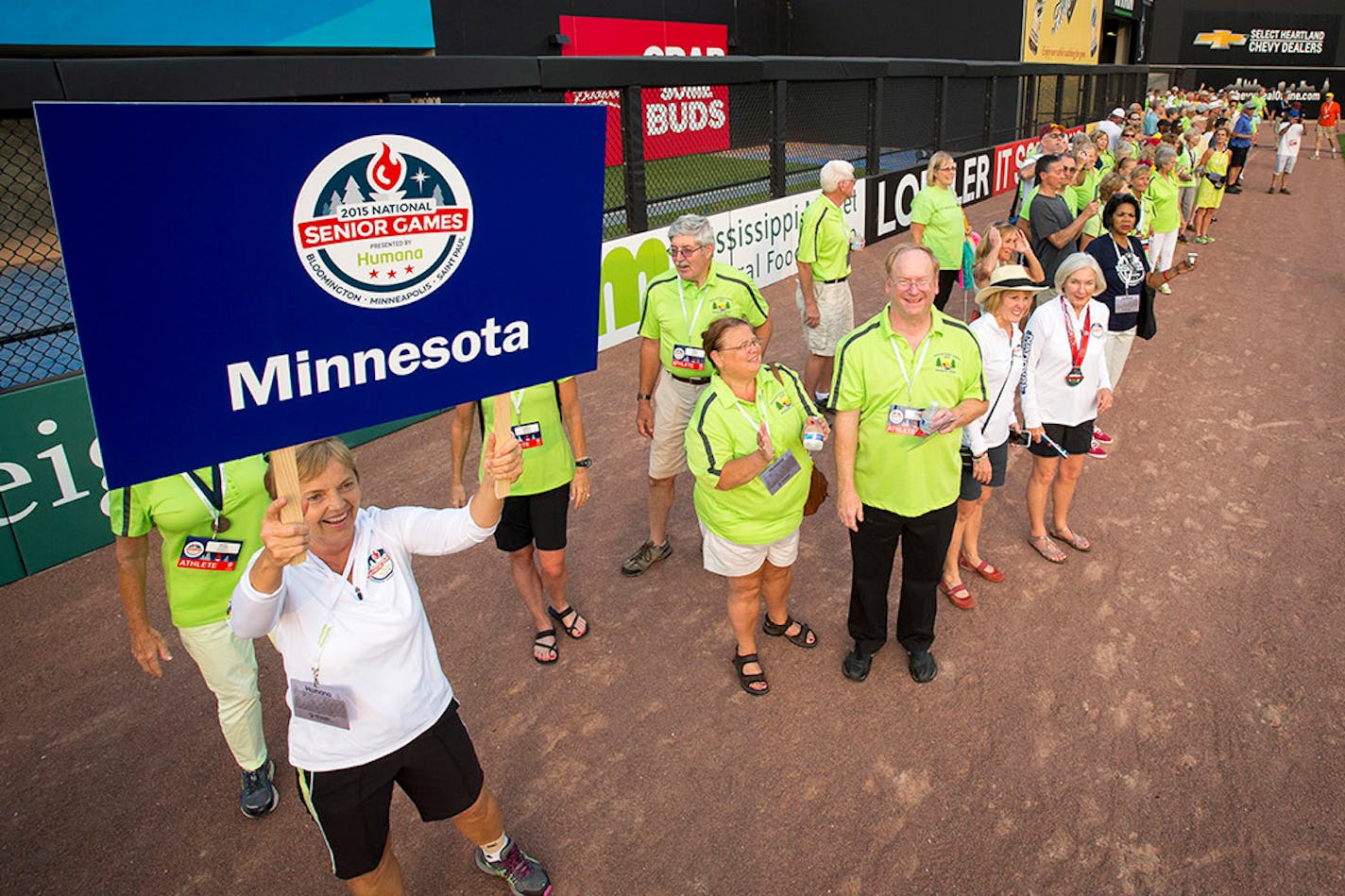 Joan Boger, of Minneapolis, held a Minnesota sign as she lead more than a hundred Minnesota athletes onto CHS Field during the National Senior Games Celebration of Athletes Friday night.