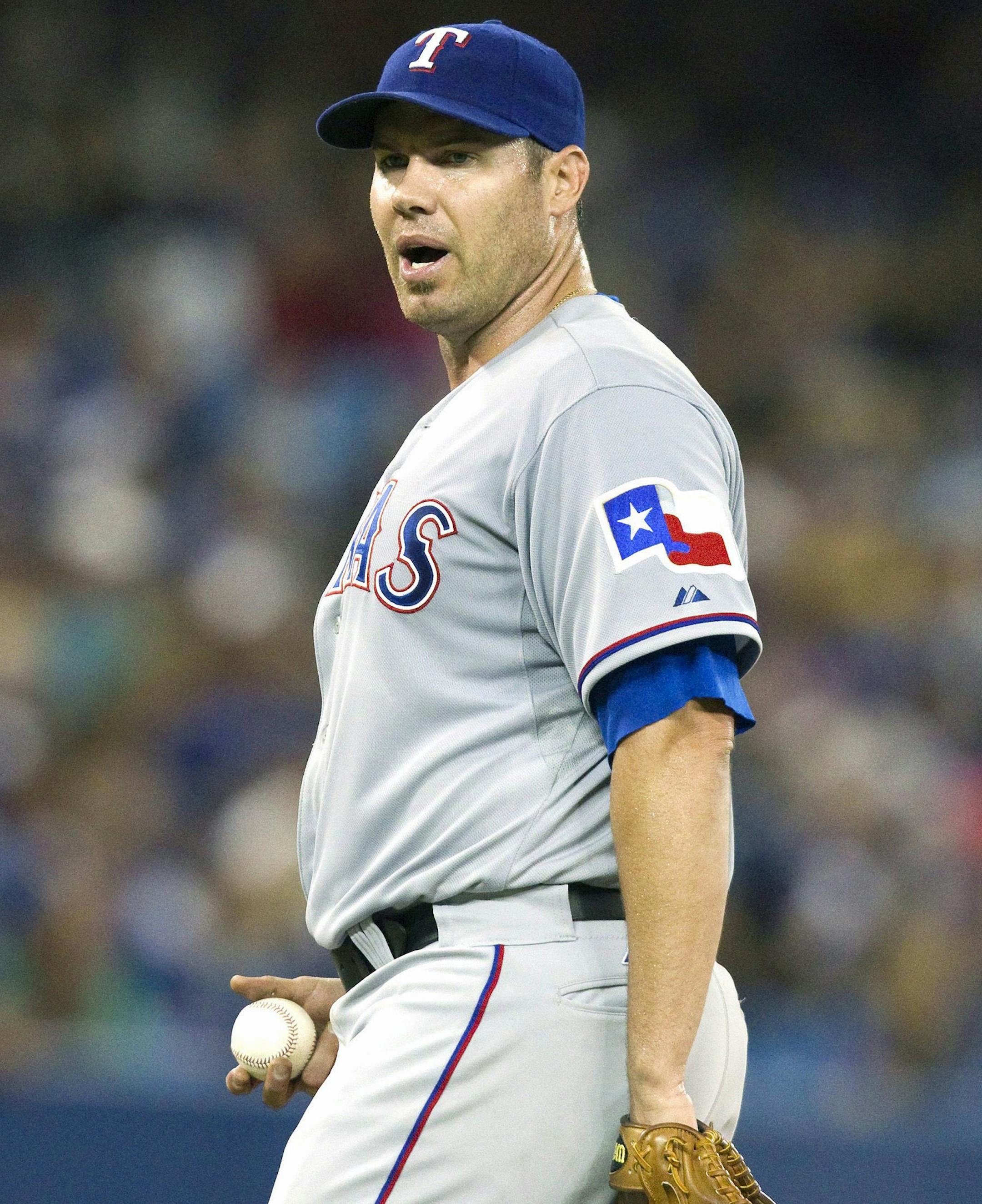 Texas Rangers starting pitcher Colby Lewis has words with Toronto Blue Jays Colby Rasmus (not shown) after Rasmus bunted his way on during the fifth inning of a baseball game, Saturday, July 19, 2014 in Toronto. (AP Photo/The Canadian Press, Fred Thornhill)