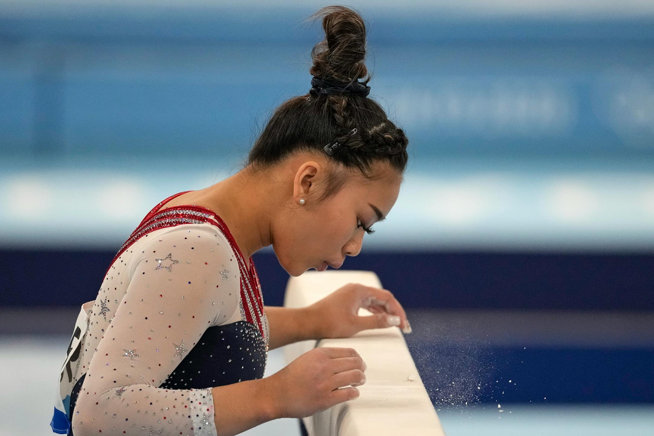 Suni Lee, of the United States, blows on the balance beam before performing on it during the artistic gymnastics women's all-around final at the 2020 Summer Olympics, Thursday, July 29, 2021, in Tokyo. (AP Photo/Ashley Landis)