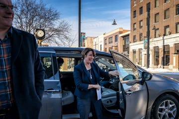 Amy Klobuchar arrives in Mason City, Iowa. Her husband John on the left.