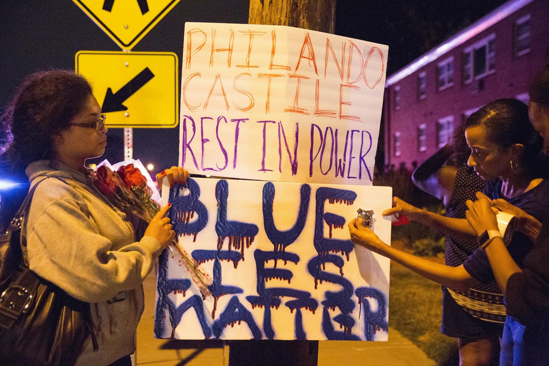 Protester's hang signs on a post near the scene of Philando Castile's shooting in Falcon Heights on Wednesday, July 6, 2016.