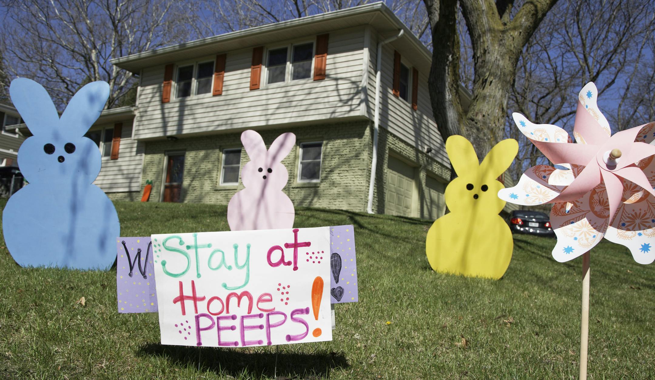 A yard sign in Omaha, Neb., Friday, April 10, 2020, urges people to stay at home. Social distancing and staying at home are some of the measures to combat the coronavirus outbreak. (AP Photo/Nati Harnik)