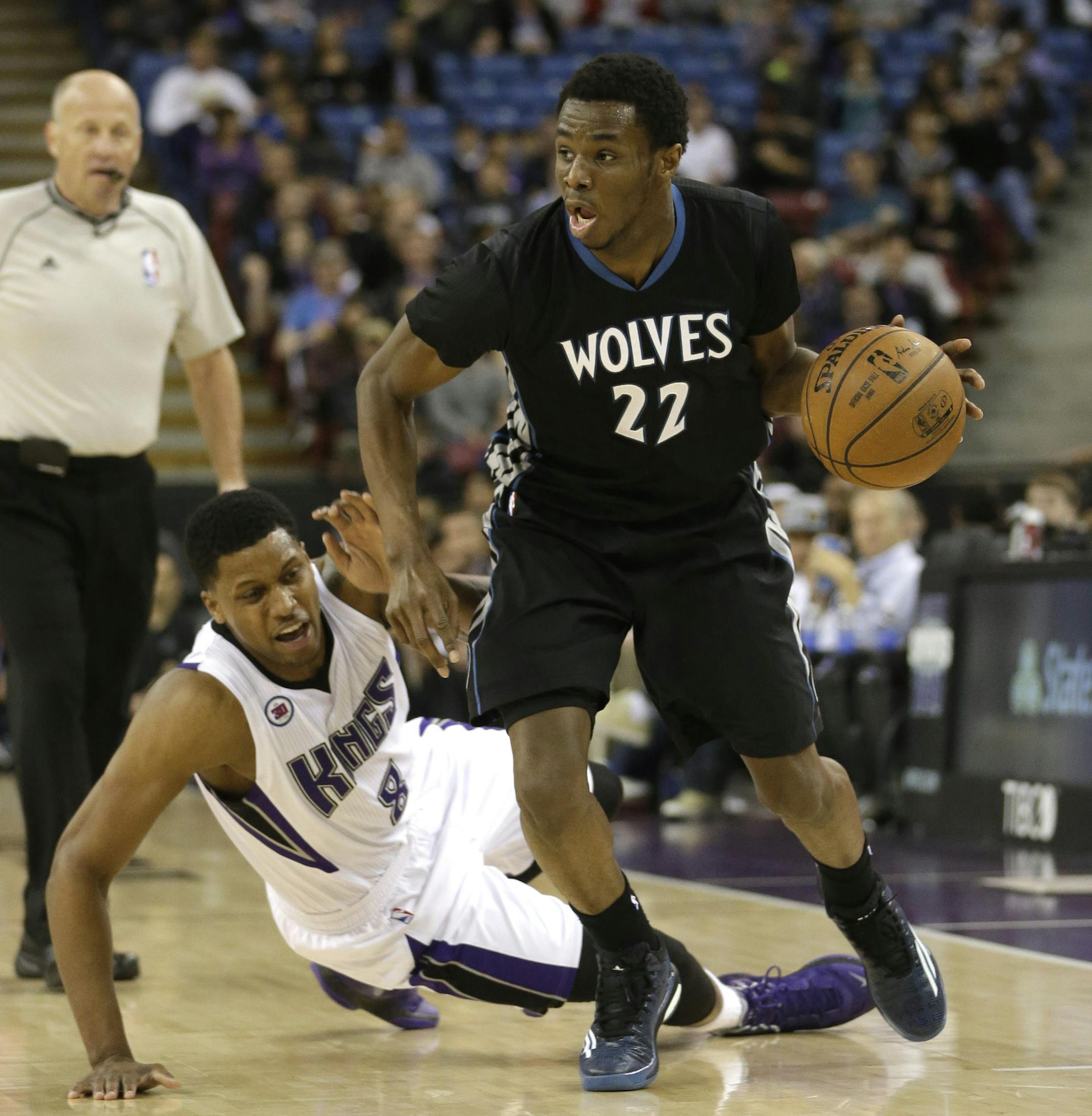 Minnesota Timberwolves forward Andrew Wiggins, right, escapes the defensive pressure of Sacramento Kings forward Rudy Gay, who tumbled to the floor during the first quarter of an NBA basketball game in Sacramento, Calif., Calif., Tuesday, April 7, 2015.(AP Photo/Rich Pedroncelli)