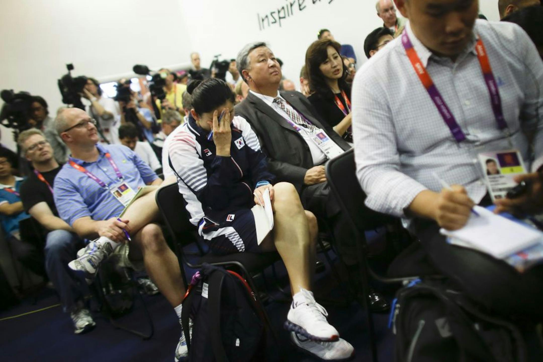 Kim Jiyhun, center, coach of South Korea's women's doubles badminton team, reacted at a news conference following the disqualification of eight players.