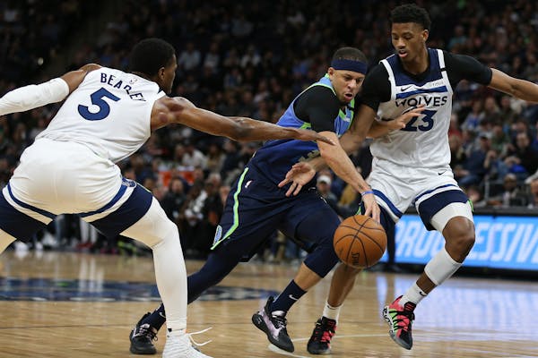 The Mavericks' Seth Curry drove between the Timberwolves' Malik Beasley, left, and Jarrett Culver in the second half at Target Center on Sunday. Dalla