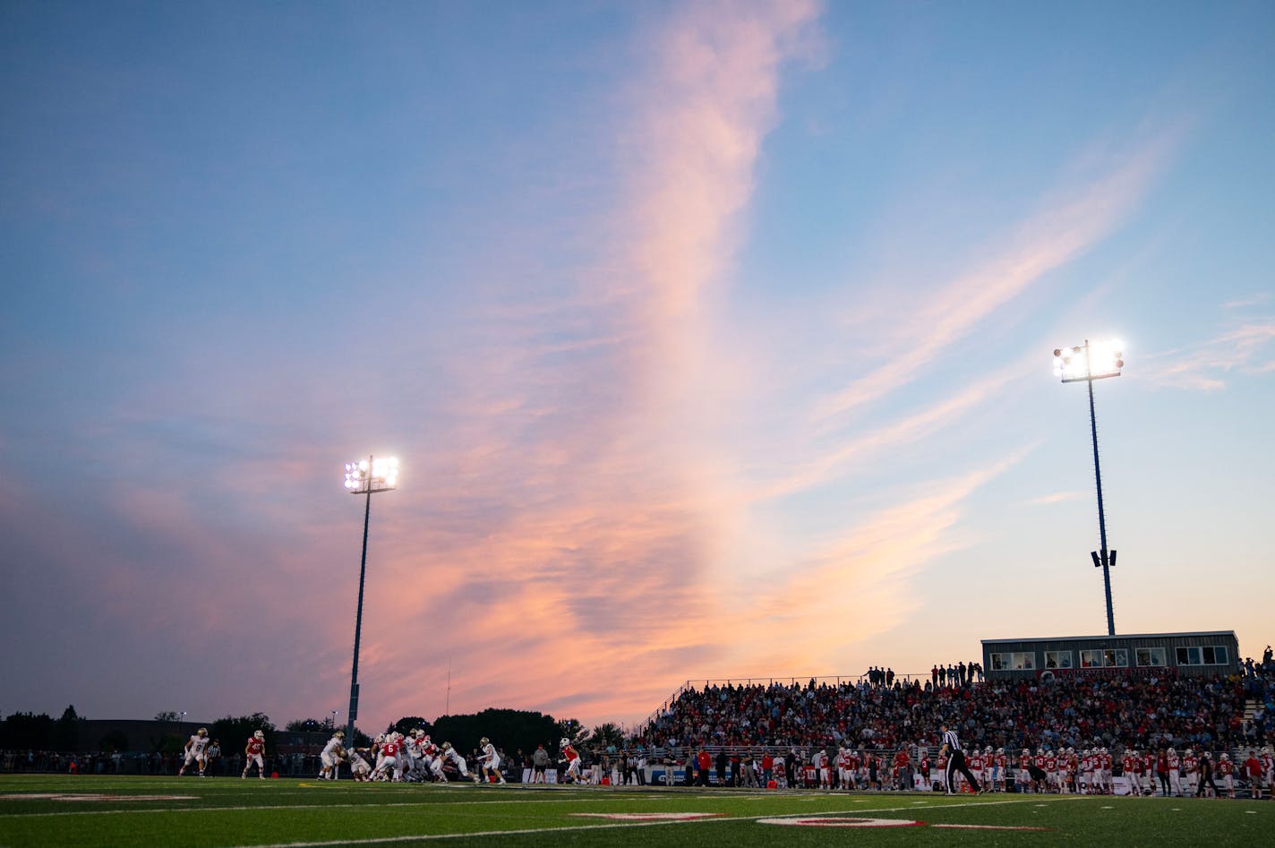 Pink clouds fill the sky in the second quarter of Lakeville North's game against Lakeville South Friday, Sep. 15, 2023, at Lakeville North High School in Lakeville, Minn. ]