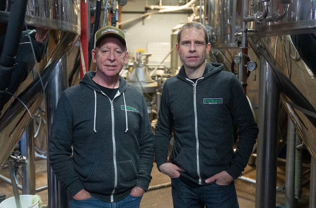 Pat Carey and Jason Myrold, co-owners of Padraigs Brewing in Minneapolis, between fermentation vessels on Feb. 2.