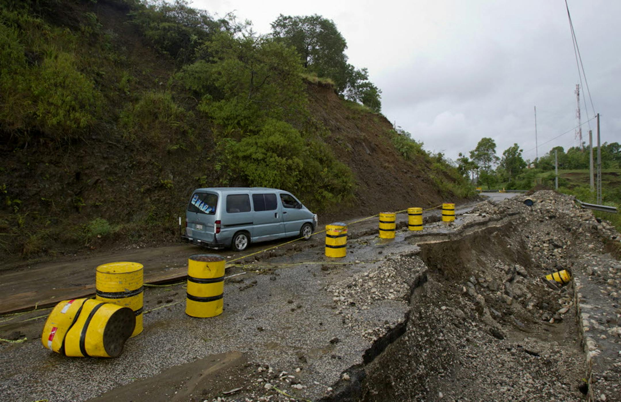 A day after Tropical Storm Isaac brought rains and winds across Haiti, a van passes carefully along a road Sunday on the route to Jacmel.