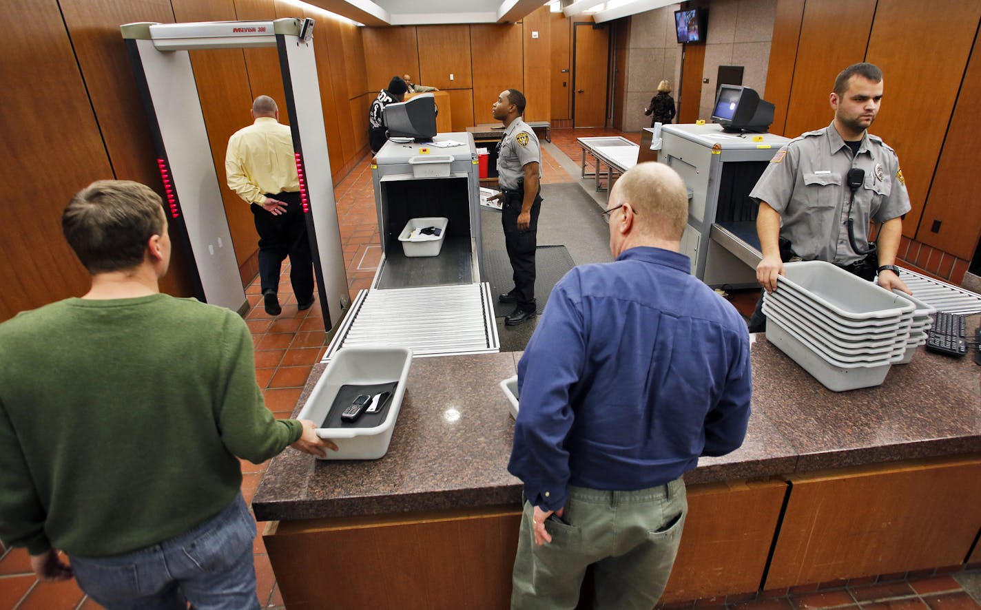 Courthouse screening is expanding in the metro area. A visual look at the screening area of the Hennepin County Government Center in Minneapolis. Viking Security agents Carlo Griggs, left, and Jon Kline checked people as they proceeded through the security machines. (MARLIN LEVISON/STARTRIBUNE(mlevison@startribune.com) ORG XMIT: MIN1312061527221829