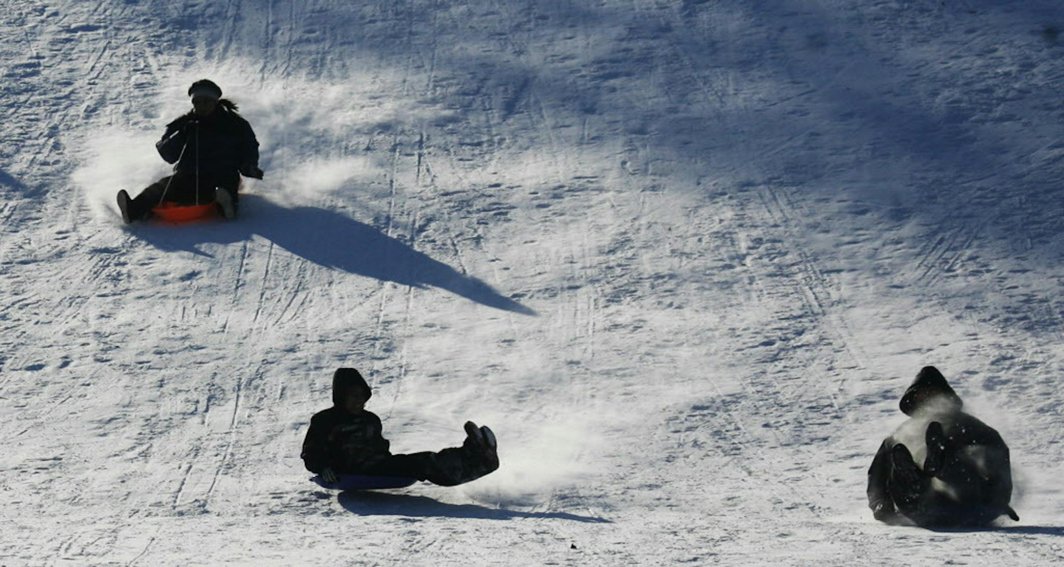 DAVID JOLES ï djoles@startribune.com Minneapolis, MN - Dec. 25, 2008-] Sledders catch some air and snow while hitting a hill along Minneahaha Parkway near S. 16th Ave. on Christmas Day.