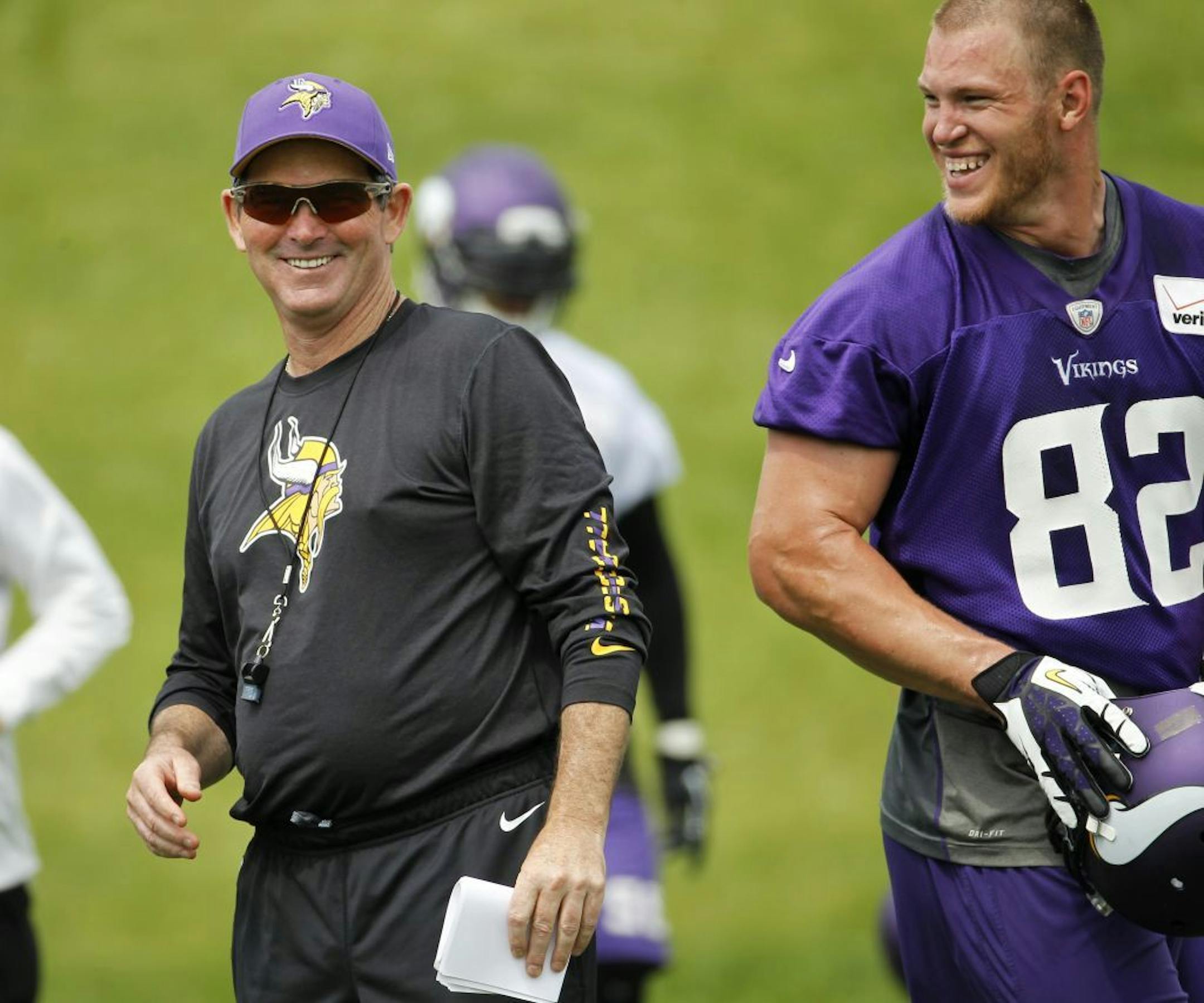 Minnesota Vikings head coach Mike Zimmer shares a laugh with tight end Kyle Rudolph (82) during an NFL organized training activity in Eden Prairie, Minn., Wednesday, June 11, 2014.