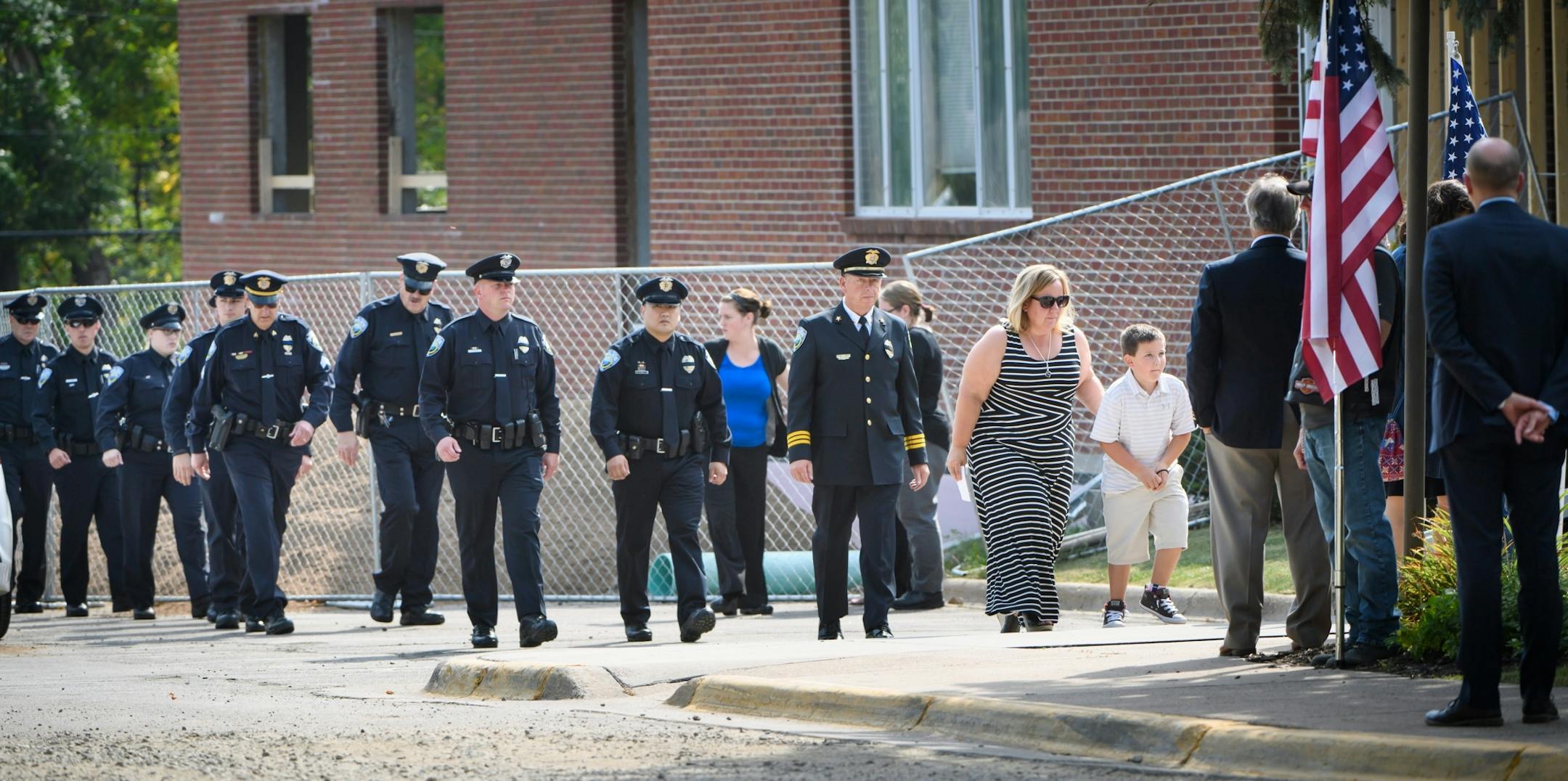 Shawn Mathews and her son, Wyatt, enter the Wayzata Free Church at the beginning of visitation for her husband, Wayzata police officer Bill Mathews, followed by members of the Wayzata Police Department.