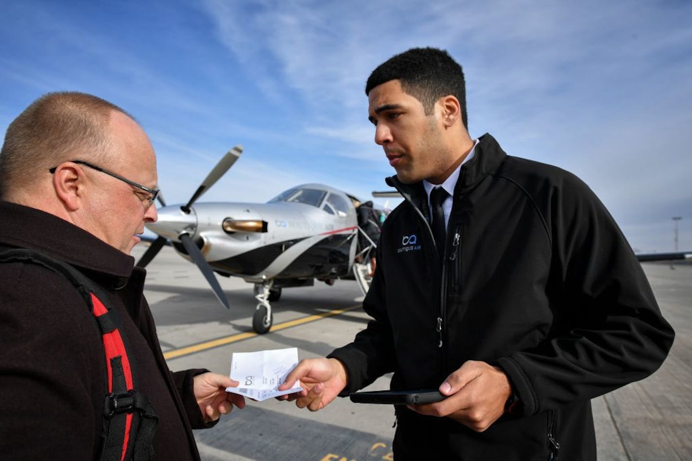 First officer Joshua Williams checked passengers boarding passes before the flight to Thief River Falls.