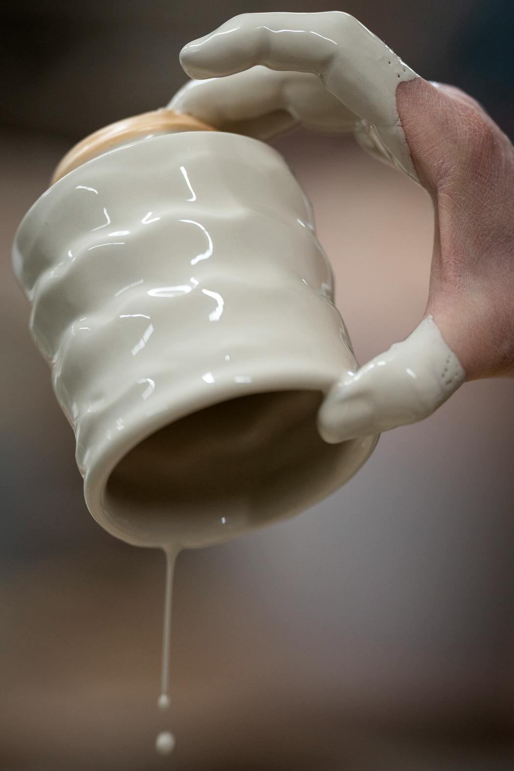 Studio manager Betsy Price applied glaze to a cup at Clay Coyote.